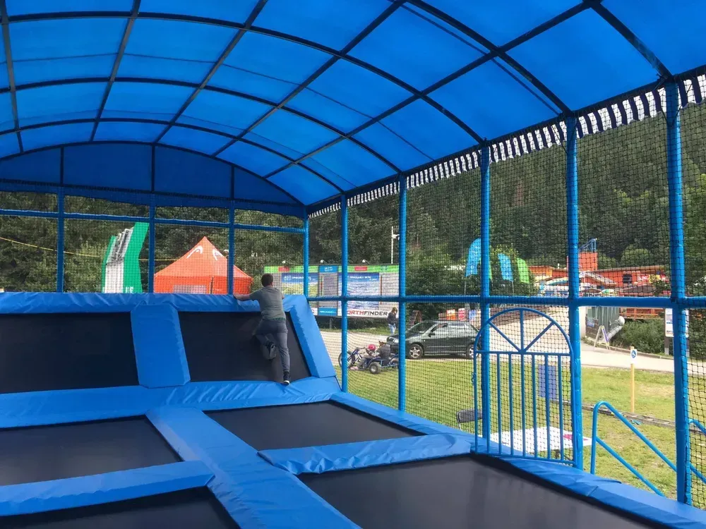 Outdoor trampolínová aréna s obloukovou střechou pro dětské areály
